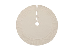 Detail of beige knitted Christmas tree skirt with intricate woven patterns and ties