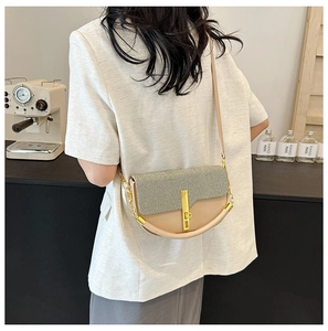 Detail of beige and gray woven crossbody bag with elegant gold hardware and chain strap