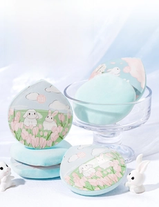 Detailed view of mint green teardrop-shaped flocked powder puff with rabbit illustration