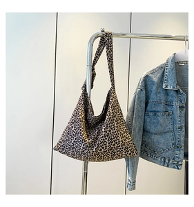 Dettaglio della grande borsa tote in tela leopardata con ampia tracolla su gruccia