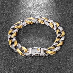 Close-up of gold and silver cuban link chain bracelet with vintage floral texture