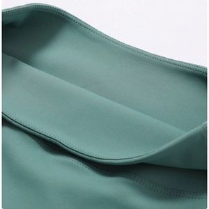 Macro detail of high-elastic seafoam green fabric with professional flatlock stitching