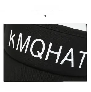 Close-up of KMQHAT white 3D embroidery on black cotton twill visor with fine stitching