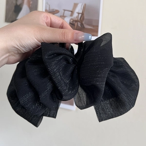 Close-up of black mesh bow hair claw clip featuring shimmering silver glitter thread