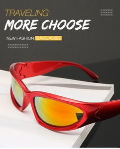 Detail of red sporty Y2K sunglasses with orange mirrored lenses on a magazine