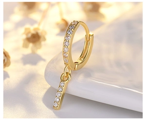 Macro shot of gold S925 silver hoop earrings with micro-paved zircons and long drops