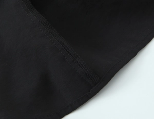 Detailed macro view of the inner stitching and high-density woven fabric on a black top