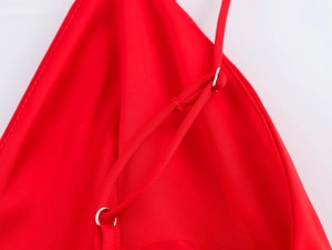 Détail de la bretelle en satin rouge avec anneau métallique et coutures de précision