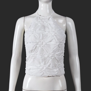 Detail of white cropped halter top featuring intricate 3D floral textured pleats