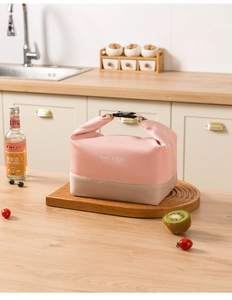 Pink and beige insulated lunch bag on a wooden kitchen counter with fruits and drinks