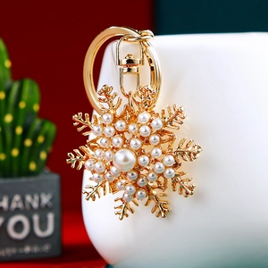 Detail shot of golden snowflake keychain with inlaid pearls on a porcelain cup edge