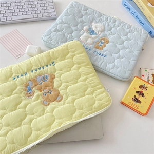 Quilted iPad sleeves with cute bear and sheep embroidery on a desk with workspace props