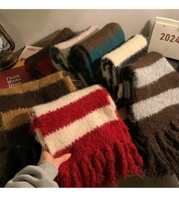 Detailed view of striped knit scarves with soft fringes in red, brown and beige colors