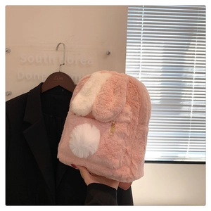 Close-up of pink faux rabbit fur backpack with cute ears and a white plush pom-pom detail