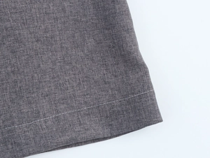 Macro view of grey suit blazer fabric with fine texture and neat white stitching detail