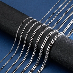 Various thicknesses of silver stainless steel Cuban link chains shown in a fanned layout