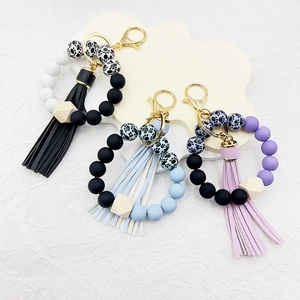 Detail of silicone bead wristlet keychains with leather tassels and leopard print beads