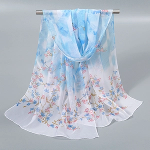 Détail d'un foulard en mousseline légère avec dégradé floral bleu et blanc sur un cintre