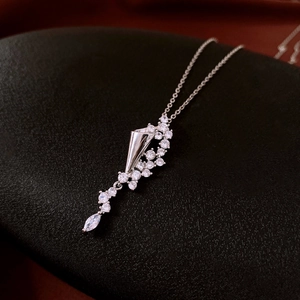 Macro detail of silver hourglass necklace with sparkling zircon stones on black texture