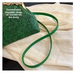 Detailed close-up of green embossed floral shell bag with intricate retro relief texture