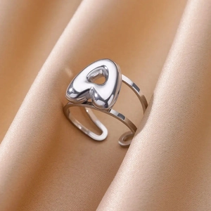 Macro shot of silver adjustable bubble letter A ring on champagne satin background