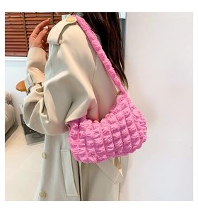 Bubble texture shoulder bag in bright pink shown with a minimalist indoor outfit