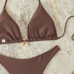 Detail of dark brown bikini top with a golden starfish pendant and S size tag