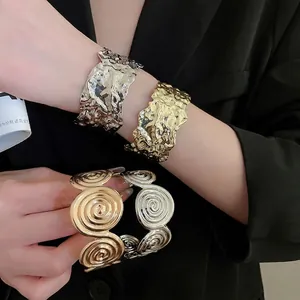 Textured metal cuff bracelets with molten and spiral patterns in gold and silver finishes