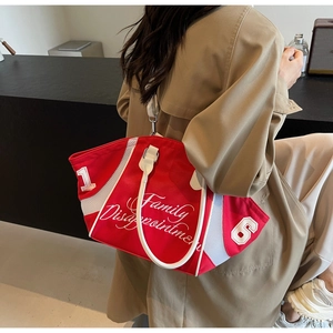 Red canvas bowling bag with white embroidery worn by a model in a minimalist setting