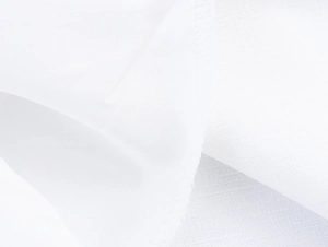 Detail shot of the white fabric texture and precision overlock stitching on the dress