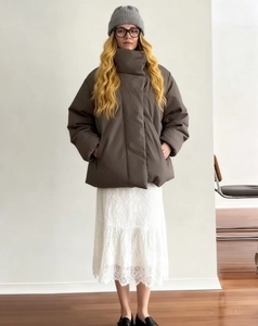 Detail of a brown puffer jacket featuring a high collar and matte fabric texture