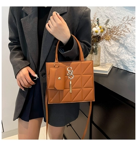 Sac bandoulière marron avec motif matelassé géométrique et pompon doré élégant