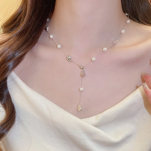 Detail of Y-shaped silver necklace with white pearls and irregular metallic beads