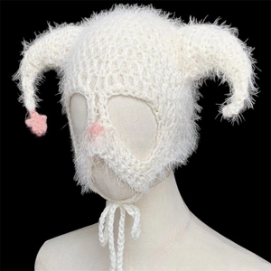 Close-up of white knit devil horn hat with pink star details and fluffy mohair texture