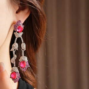 Detailed view of vintage silver tassel earrings with magenta gemstones and rhinestones