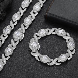 Macro shot of silver hip-hop jewelry set featuring marquise stones and X-shape links