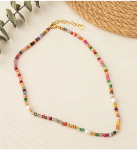 Detail of colorful stone beaded necklace with white pearls and gold lobster clasp