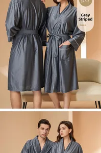 Detail of grey striped bathrobe with white piping trim and elegant silk-like texture