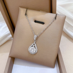 Close-up of a shimmering water-drop pendant necklace with micro-pave crystals on gold display