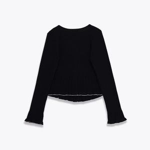 Detail of black ribbed knit long sleeve top with ruffle hem and elastic texture