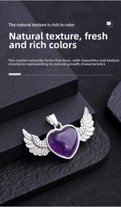 Macro shot of natural purple amethyst heart pendant with sparkling silver angel wings