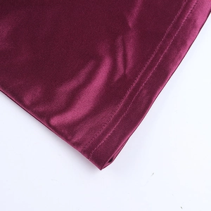 Vue détaillée du tissu en satin bordeaux montrant les coutures et la texture brillante