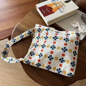 Close-up of vintage beige linen tote with intricate colorful floral star embroidery