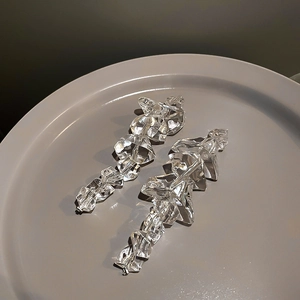 Detail of irregular acrylic ice cube earrings featuring a clear aesthetic and vintage drop style
