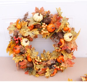 Detailed view of autumn wreath with orange pumpkins, pine cones, and faux maple leaves