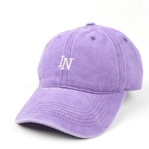 Detail of purple washed cotton baseball cap featuring white LN letter embroidery