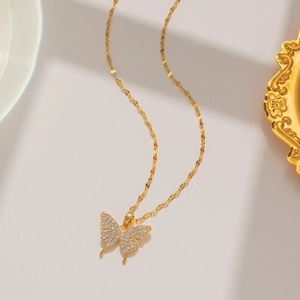 Detailed close-up of a gold butterfly necklace featuring sparkling zircon pave crystal