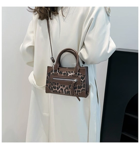 Bolso de mano con estampado de leopardo, ribetes de cuero marrón y correa de hombro