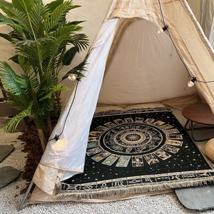 Detail of bohemian astrology woven blanket with fringe and zodiac constellation patterns