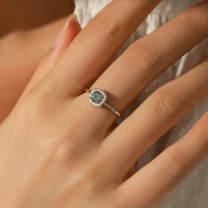 Elegant s925 silver halo ring with a round grey-blue moissanite stone worn on a hand